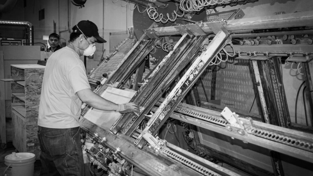 An employee assembling a standard grade cabinet door in a door press.