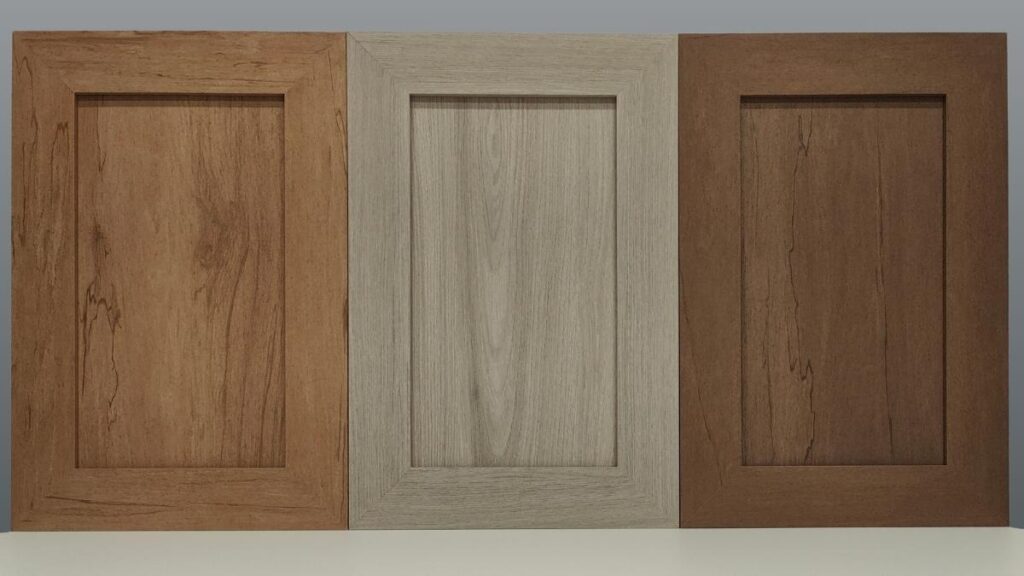 Three NEXGEN cabinet doors - from left to right, a light brown, a grey, and a medium brown.