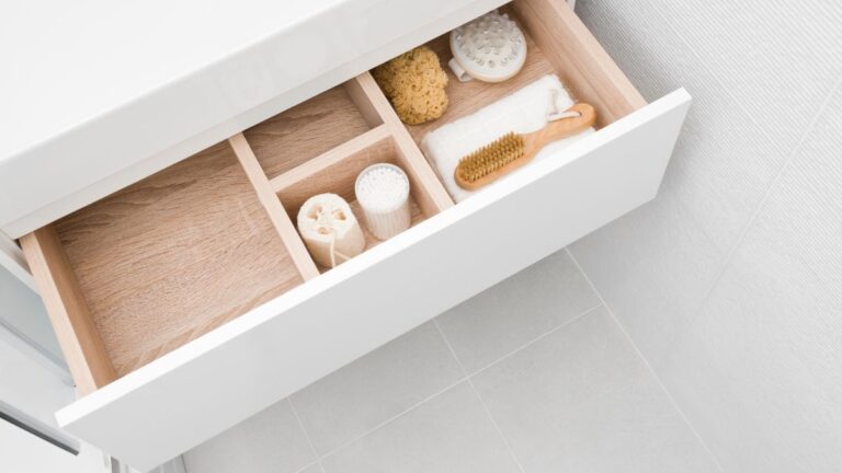 An overhead view of a wooden drawer box with dividers splitting it into four compartments.