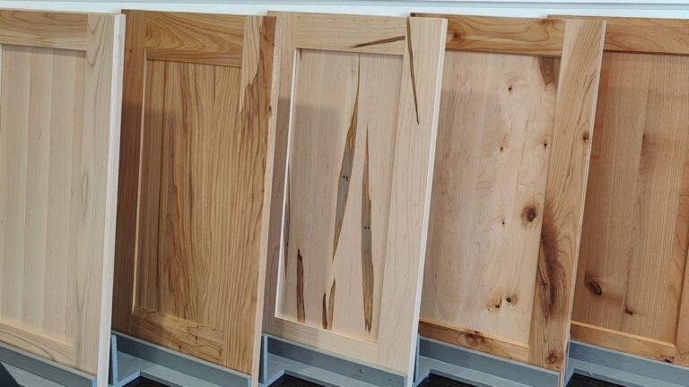 Five shaker style cabinet doors with solid wood panels in a variety of wood species.