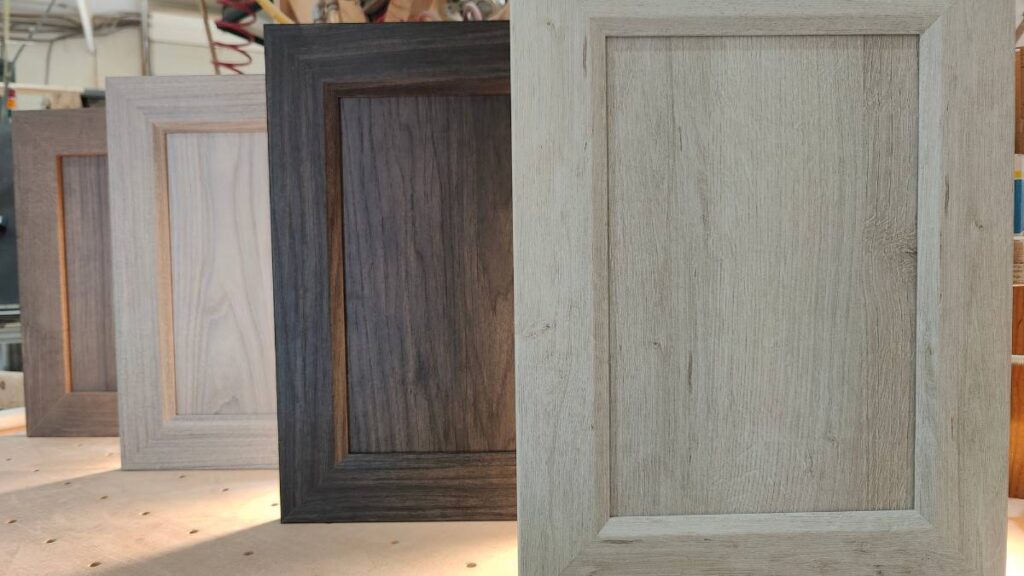 Four NEXGEN cabinet doors standing upright on a pegboard table.