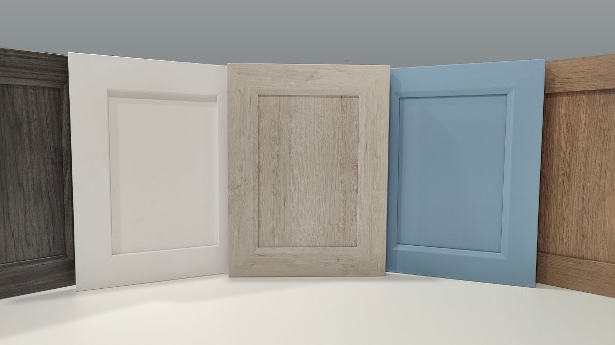 A variety of NEXGEN cabinet doors - from left to right, dark grey, white, light grey, light blue, and brown.