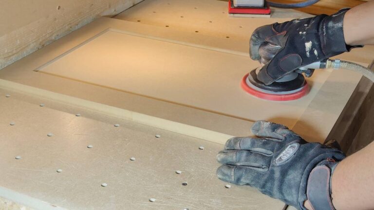 An employee sanding a 1-piece MDF cabinet door.