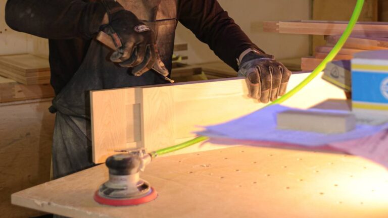 An employee filling defects in paint-grade wood.