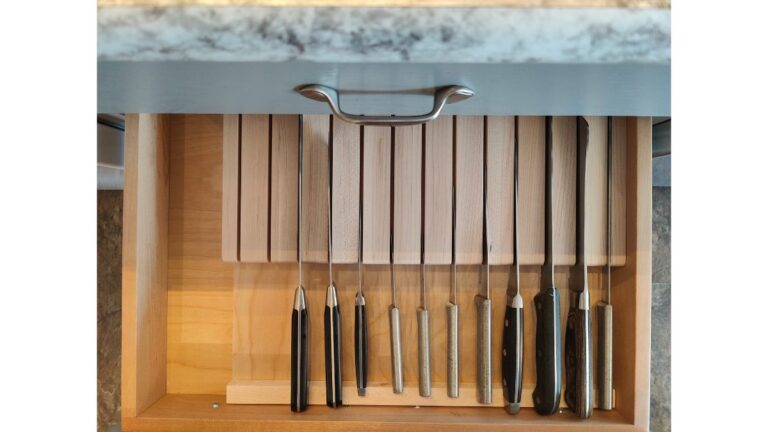 An overhead view of a Maple in-drawer knife block containing multiple kitchen knives.