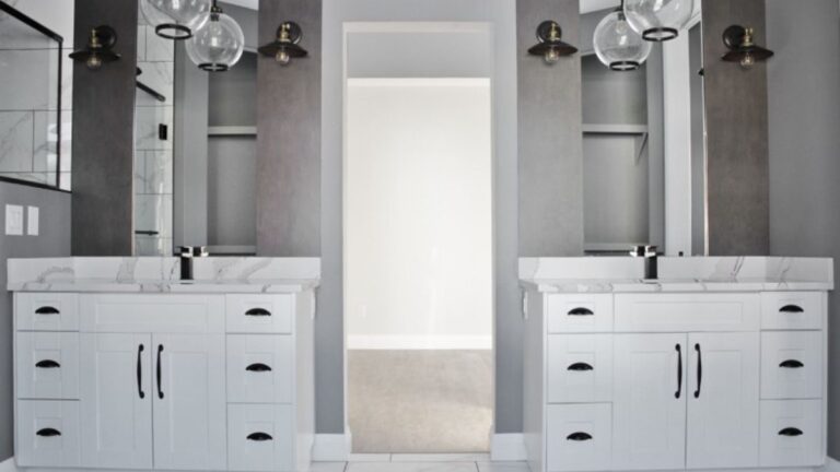 Matching vanities with white painted cabinet doors on either side of a doorway.