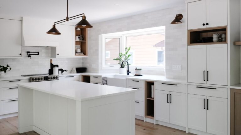 A kitchen with white painted 1-piece MDF cabinet doors, black hardware, and Rift Cut White Oak accents.