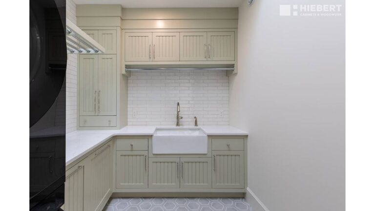 Painted solid wood cabinet doors, like the pale-green doors in this laundry room, can have problems like cracked finishes.