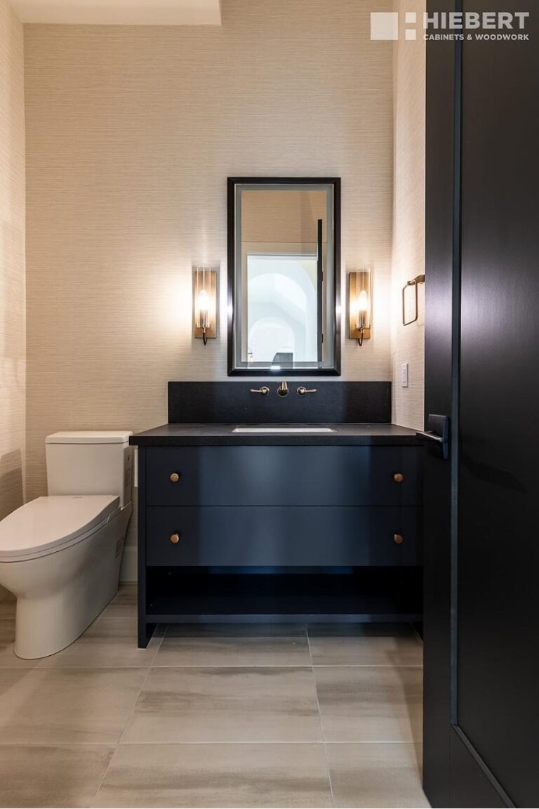 A vanity featuring navy painted flat slab drawer fronts and brass handles.