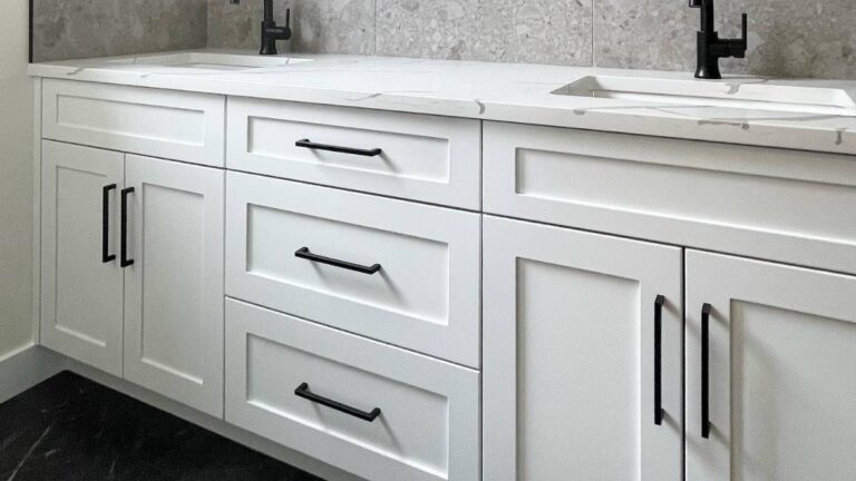 A vanity with white painted cabinet doors. The centre bank of drawer fronts contains both full-size and reduced-rail drawer fronts.