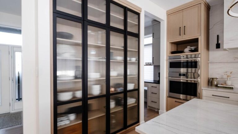 This kitchen uses a wall of glass cabinet doors with black metal frames to make the space feel brighter.