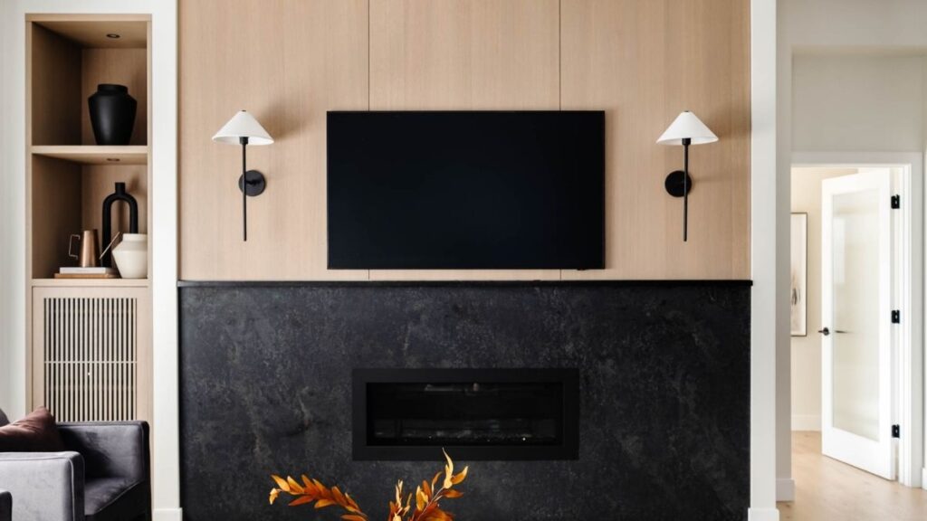 This living room features a black fireplace surround with Rift Cut White Oak slabs above the mantel.