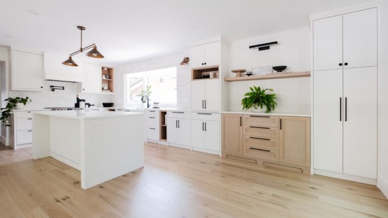 This contemporary kitchen features mostly white painted cabinet doors with a feature item of Rift Cut White Oak cabinet doors and wood accents.