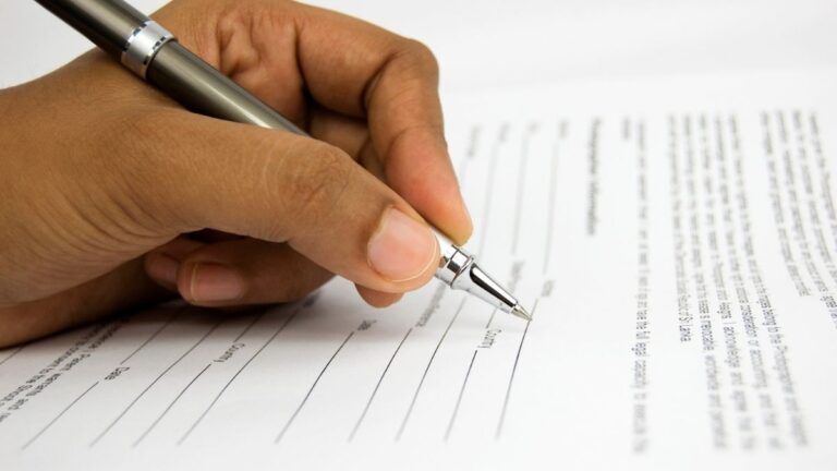 An image showing a hand holding a pen hovering over a printed form. To start working with Cutting Edge Doors, you must request your contractor account online.