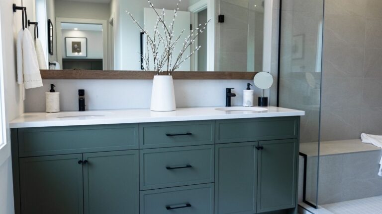 A vanity with teal 1-piece MDF slim shaker cabinet doors and black hardware.