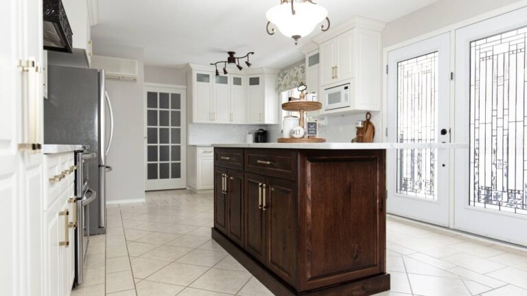 A kitchen with white painted perimeter doors and brown stained wood doors on the island. To prevent delays and avoid rush fees, order your custom cabinet doors at least 4 weeks in advance.