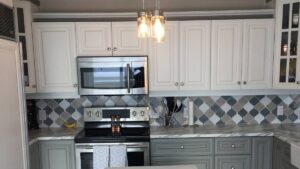 A kitchen with white painted uppers and gray painted lower cabinet doors. Armstrong Painting & Renovation works with homeowners in Edmonton.