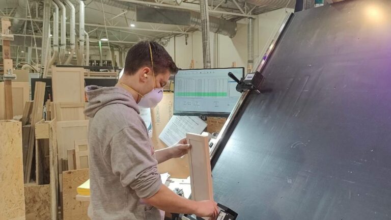 A Cutting Edge employee inspecting the outside edges of a cabinet door. All cabinet doors go through a multi-step quality inspection.