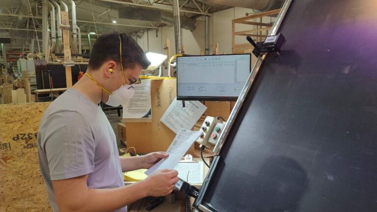 A Cutting Edge employee looking at an order form. The first step for inspecting cabinet doors is to ensure they know what was ordered.