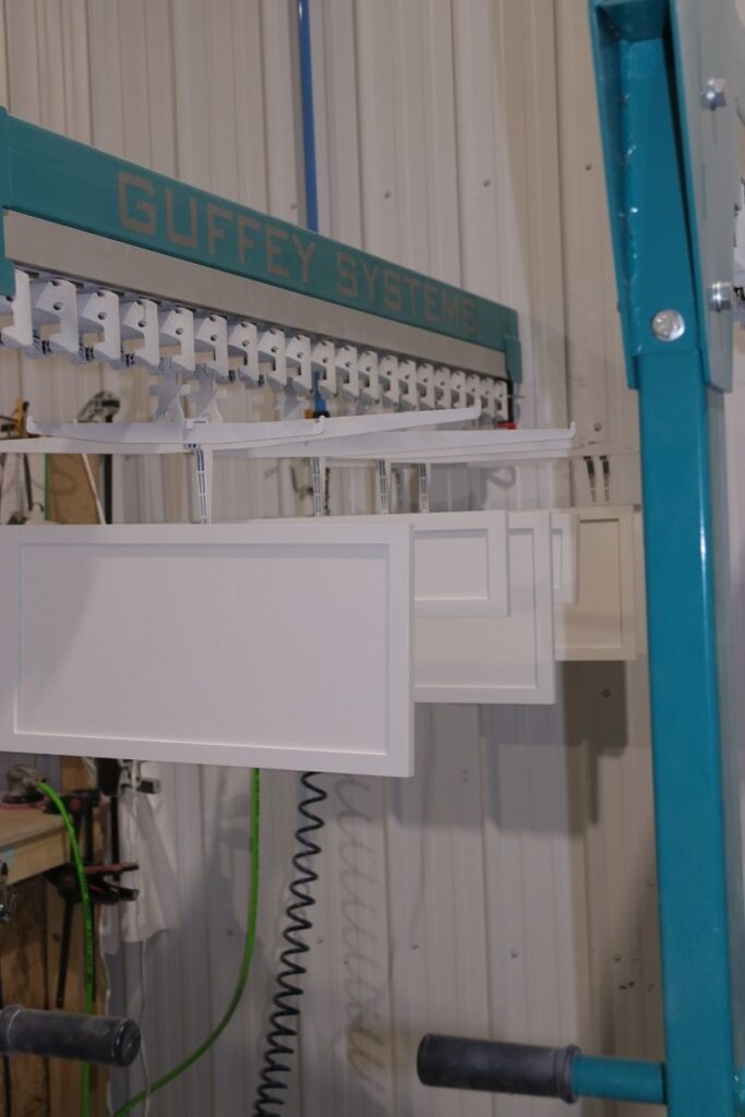 A rack of finished MDF cabinet doors in Cutting Edge's spraybooth.