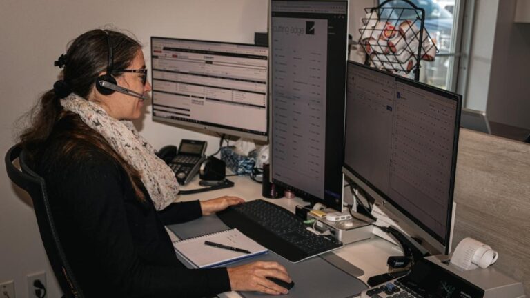 A Cutting Edge employee sitting at her desk. Cutting Edge notifies you by email if your finished cabinet doors are delayed.