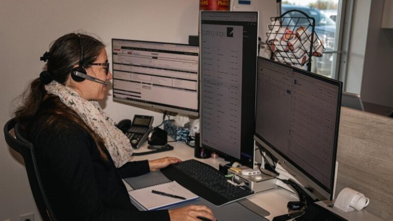 A Cutting Edge employee sitting at her desk. Cutting Edge notifies you of order delays at least 24 hours in advance.