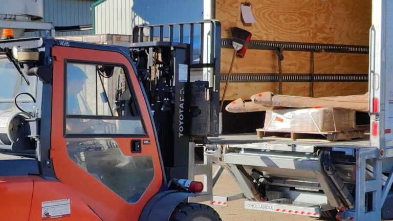 An orange forklift loading a pallet into a semi trailer. Cutting Edge typically ships large shipments to Moose Jaw via Manitoulin Transport.