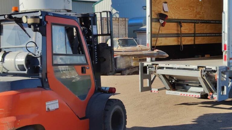 An orange forklift loading a pallet of cabinet doors into a semi trailer. Cutting Edge ships to Prince Albert via Manitoulin Transport.