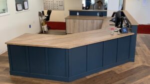 A front desk with blue painted panels and a wood butcher block top. Lome Carpentry works with homeowners and businesses in Regina.