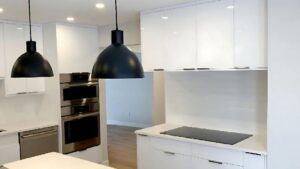 A kitchen with white high gloss cabinet doors. Lome Carpentry works with homeowners and businesses in Regina.