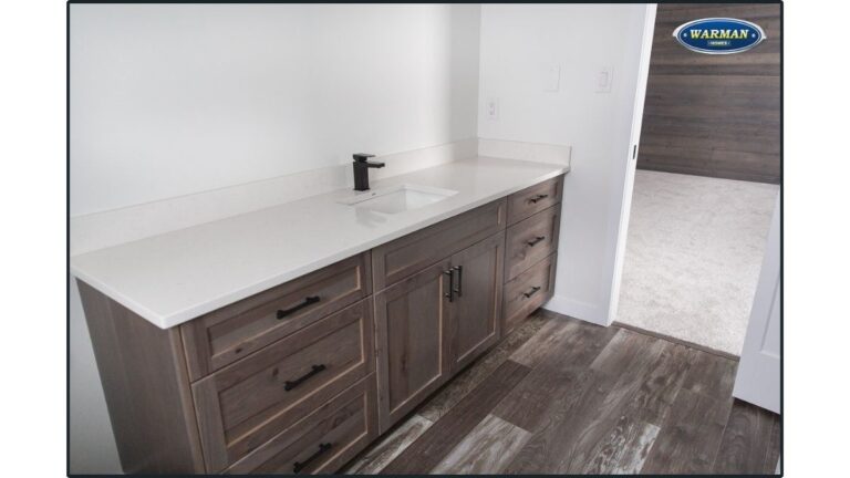 A vanity featuring grey-brown stained cabinet doors and drawer fronts. Using a wiping stain instead of a spray stain results in a warmer finish.